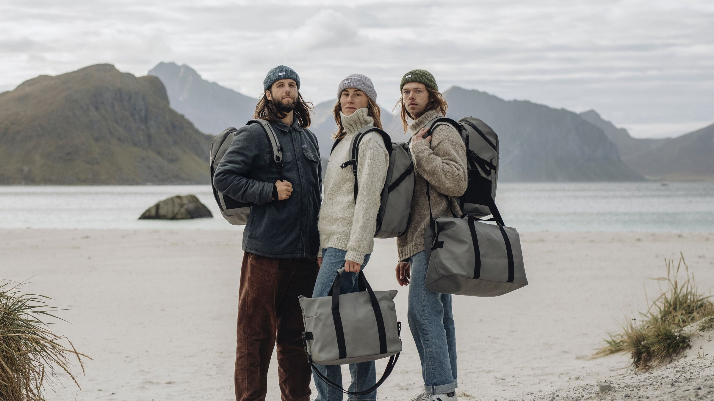 Travel, weekendbag, suitcase - 3 people in Lofoten Norway with backpacks and weekendbags.